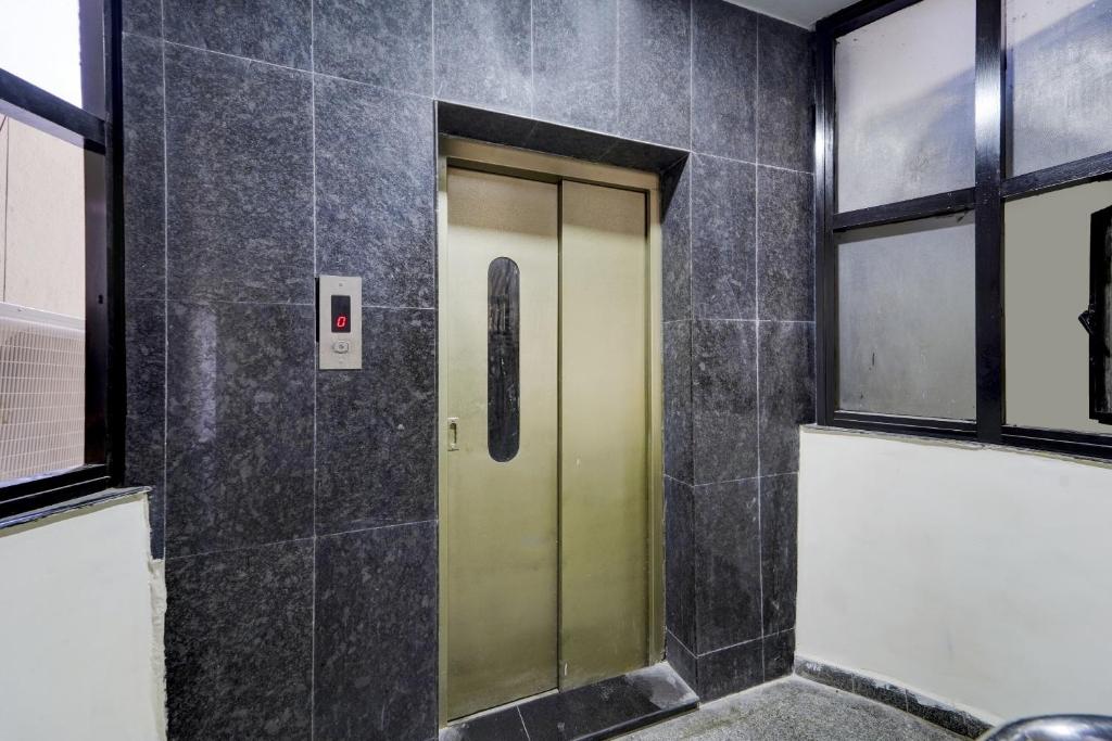 un ascensor en un baño con azulejos negros en Townhouse 1090 Fantasea Hotels Near OMR en Chennai