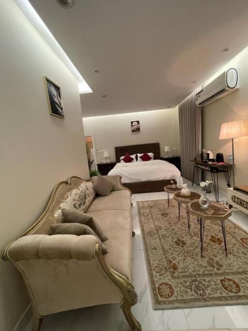 sala de estar con sofá y cama en شالية خاص مع جناح فندقي en Ḩayy aş Şāliḩīyah