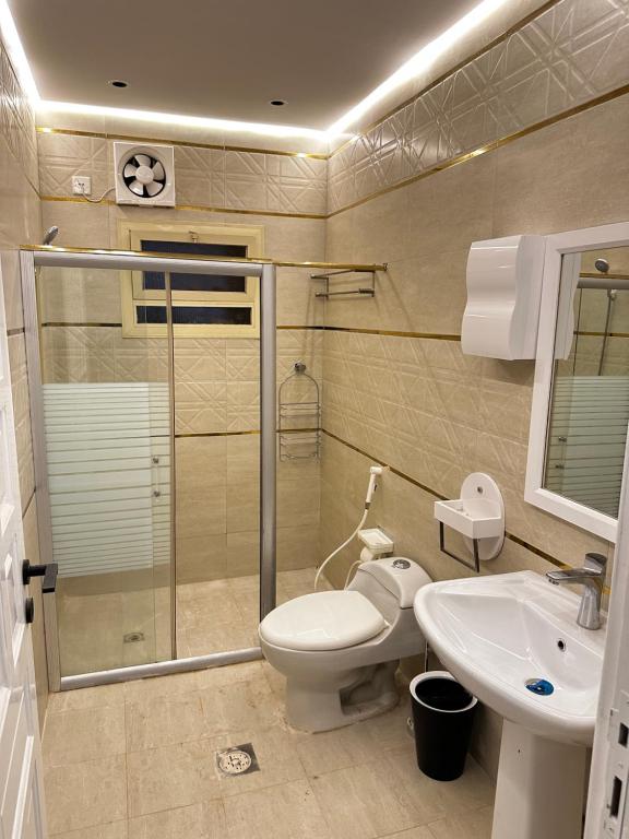 a bathroom with a shower and a toilet and a sink at Mangroves luxury suites in Al Madinah