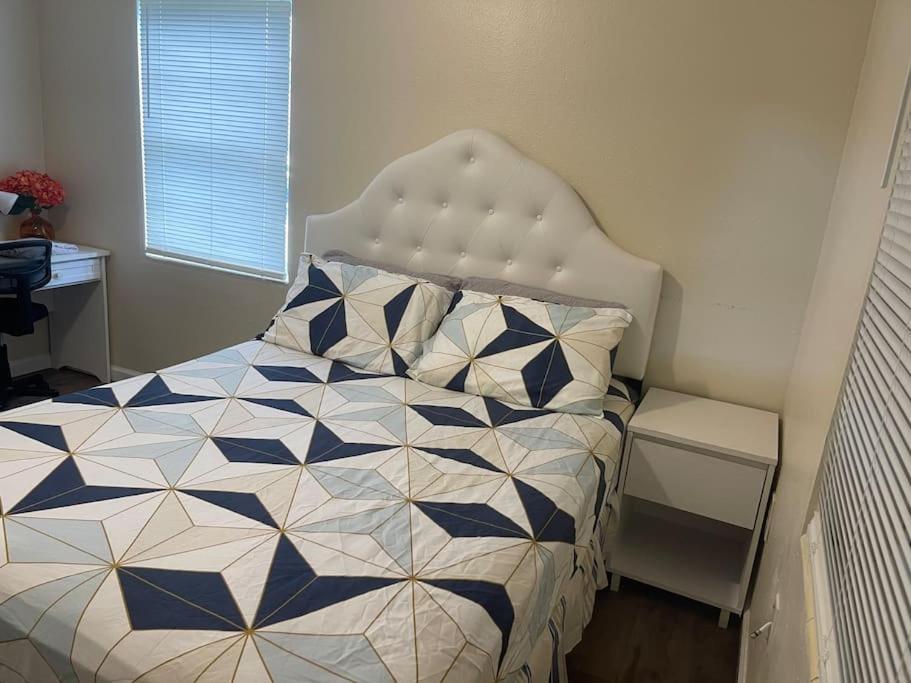 a bedroom with a bed with a blue at Private Queen Bedroom B house shared common spaces in Fort Pierce