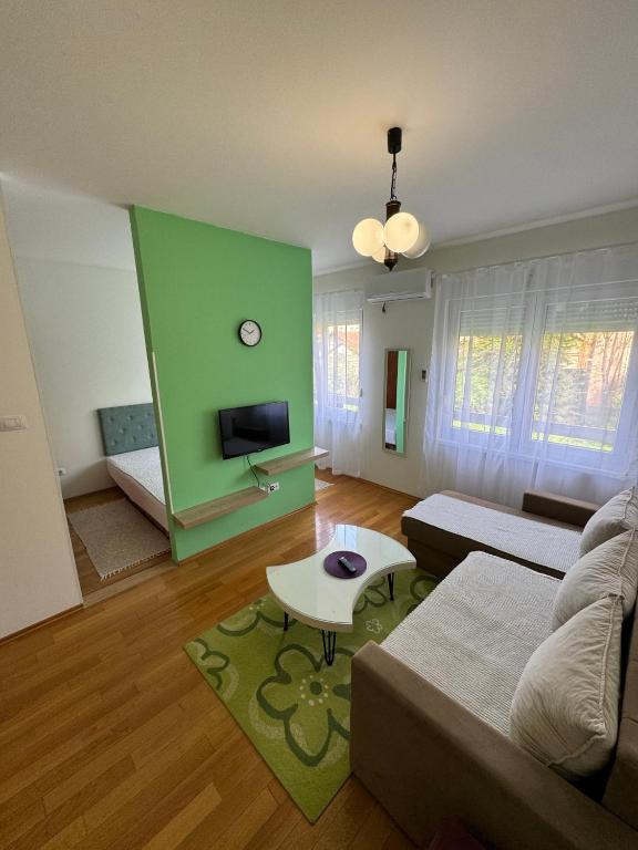 sala de estar con pared verde y sofá en Studio 33, en Banja Luka