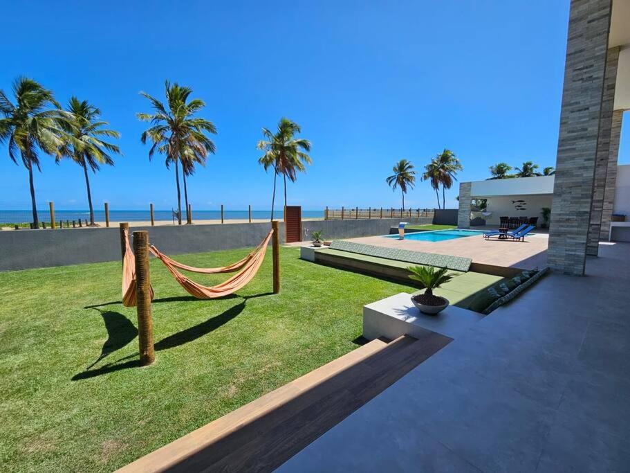a backyard with a hammock and a view of the beach at Beira mar com vista espetacular! Quinta da Barra! in Barra do Sirinhaém