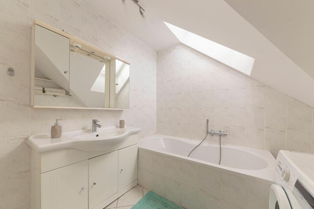 uma casa de banho branca com um lavatório e uma banheira em Apartment Tati em Dol pri Ljubljani