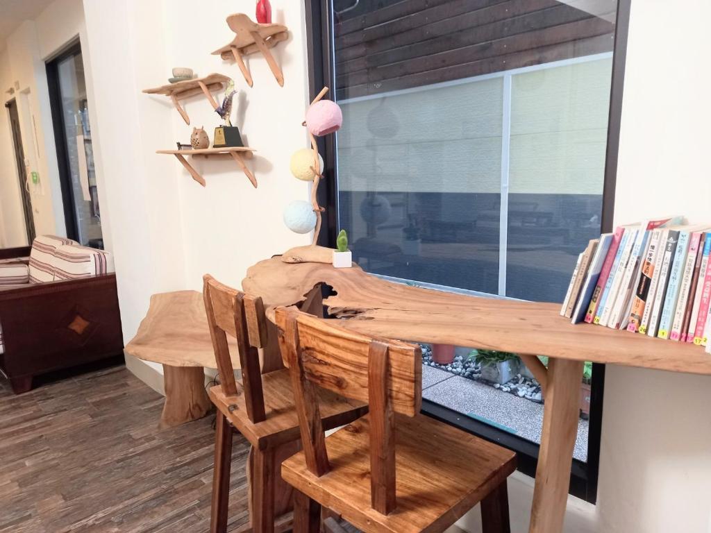 a dining room with a wooden table and chairs at Mixa Hostel in Hualien City