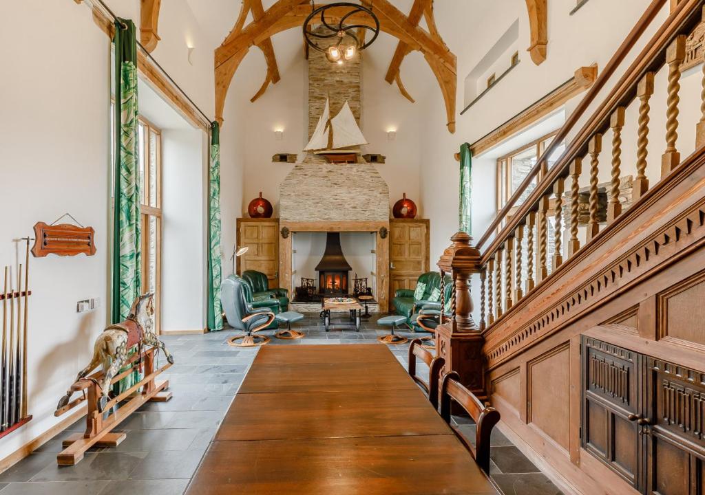 a living room with a staircase and a fireplace at Otter Pool Barn in West Down