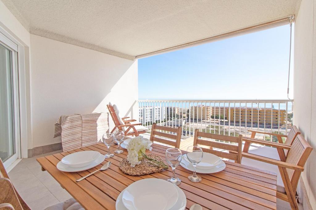 ein Esszimmer mit einem Tisch und Stühlen sowie einem Balkon in der Unterkunft Global Properties, Apartamento con vistas al mar, Canet d'en Berenguer in Canet d'en Berenguer