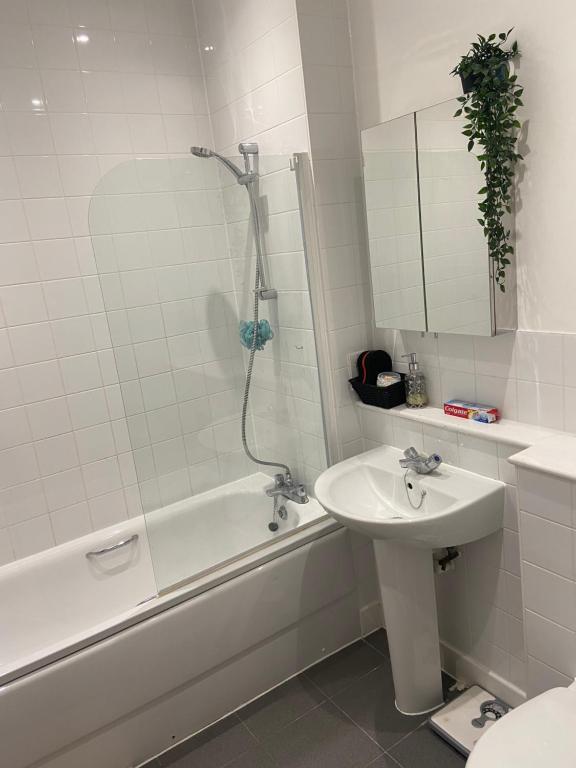 y baño con lavabo, ducha y bañera. en Enfield homes en Londres