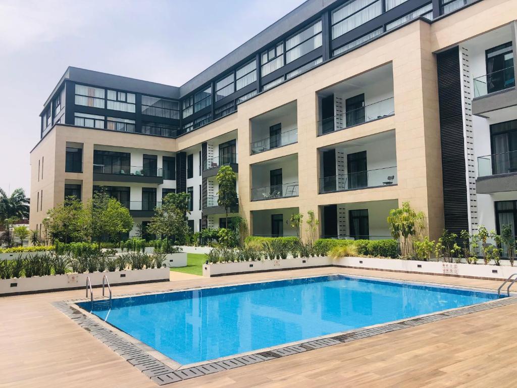 un immeuble d'appartements avec une piscine en face dans l'établissement Luxurious 2 Bedroom Apartment @Embassy Garden, à Accra