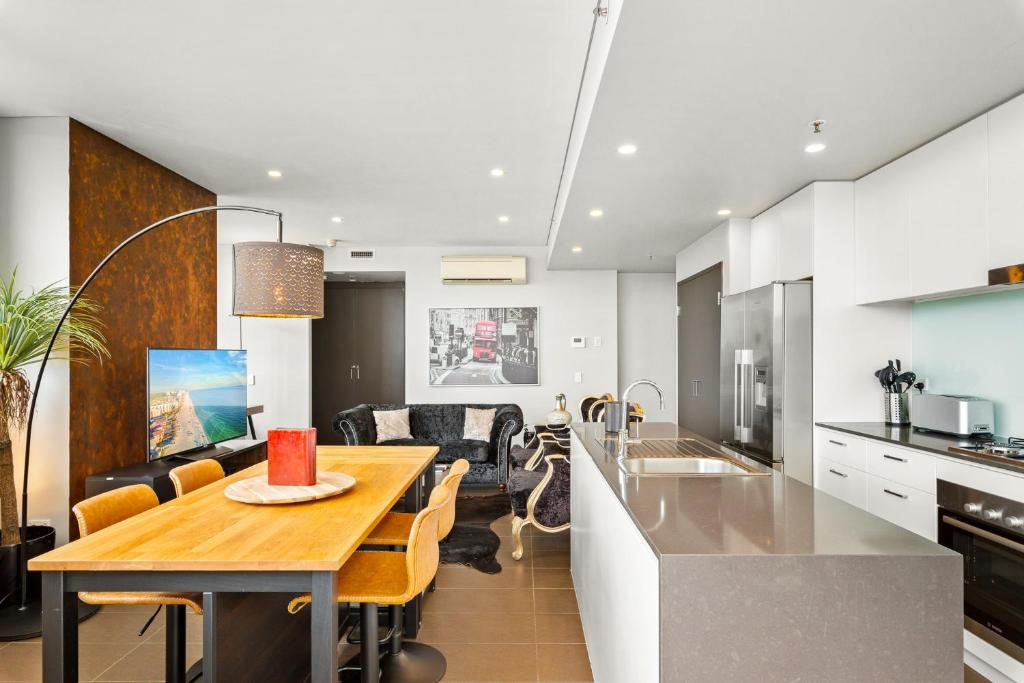 a kitchen and living room with a table and a dining room at Elegant 1-Bed by Riverside Park & Amenities in Sydney