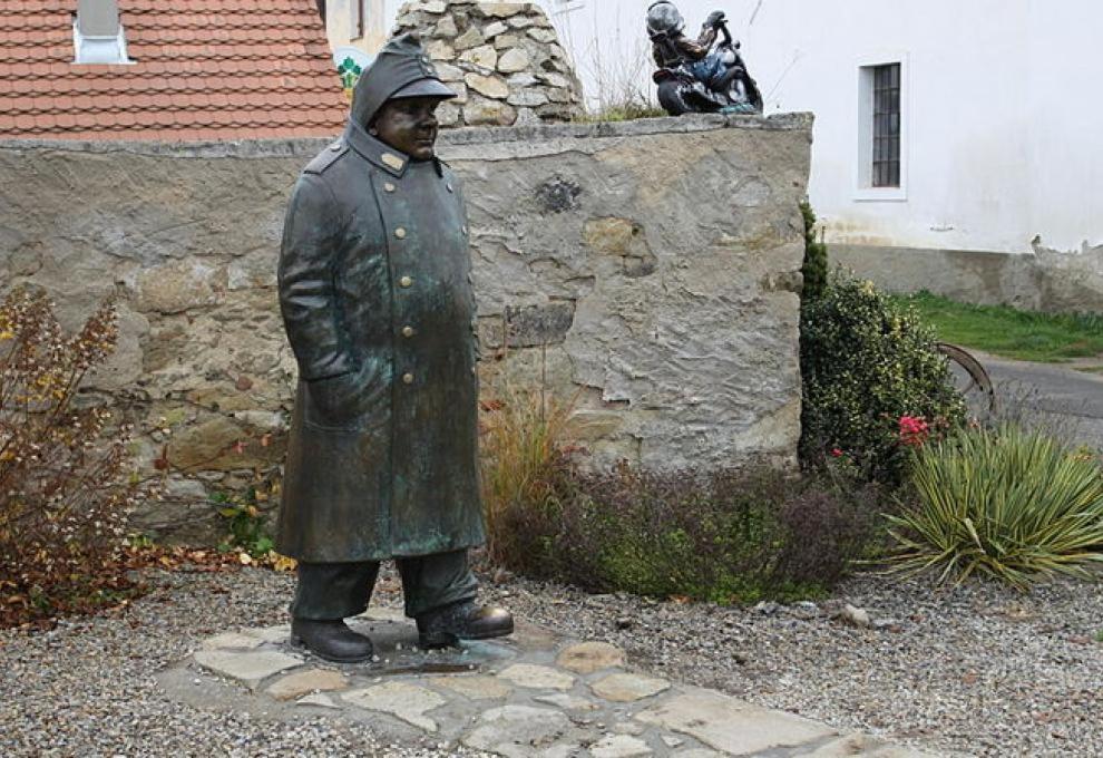 a statue of a man standing next to a stone wall at Apartmán Putim in Písek