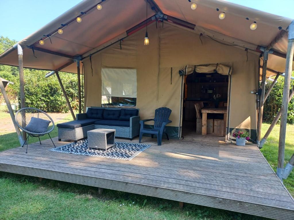 a tent with a couch and a table at Luxe Safaritent voor het hele gezin I 6 personen in Epe