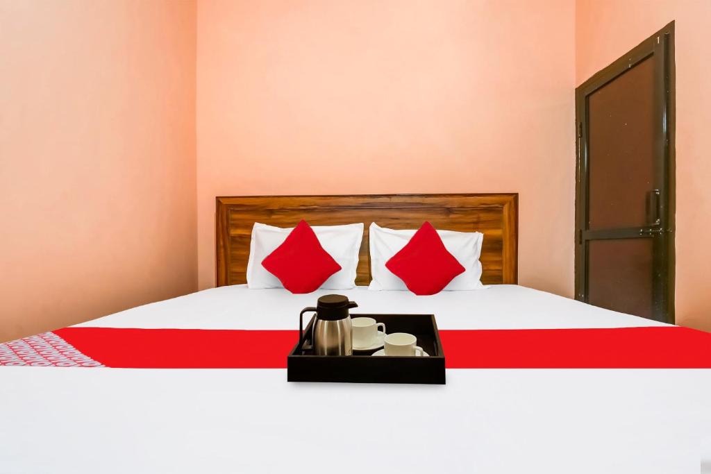ein Hotelzimmer mit einem Bett mit roten Kissen in der Unterkunft OYO Hotel Swagat in Zirakpur
