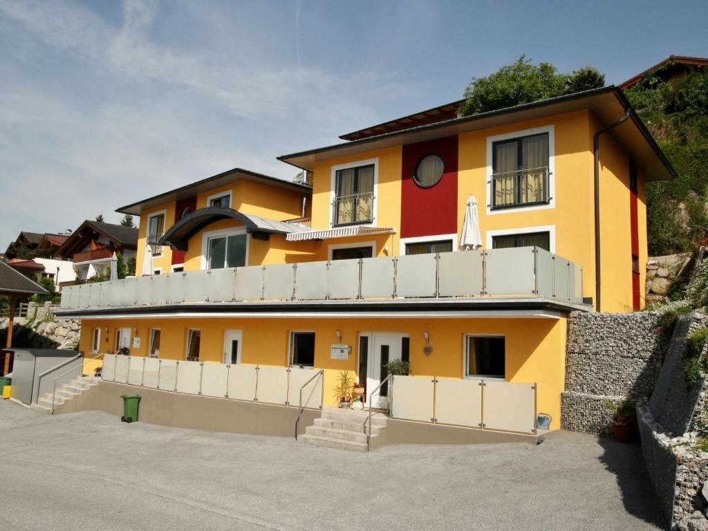 uma casa amarela e laranja com uma cerca branca em Spacious Chalet in Piesendorf with Sauna em Piesendorf