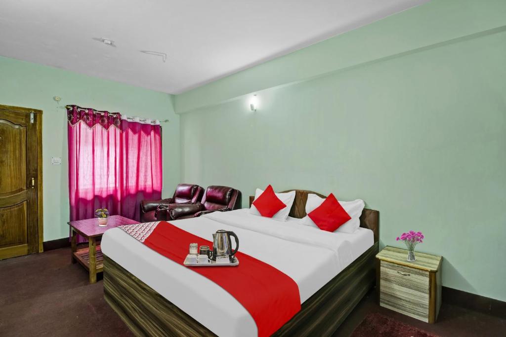 - une chambre avec un grand lit et des oreillers rouges dans l'établissement Flagship Evergreen Guest House, à Shillong