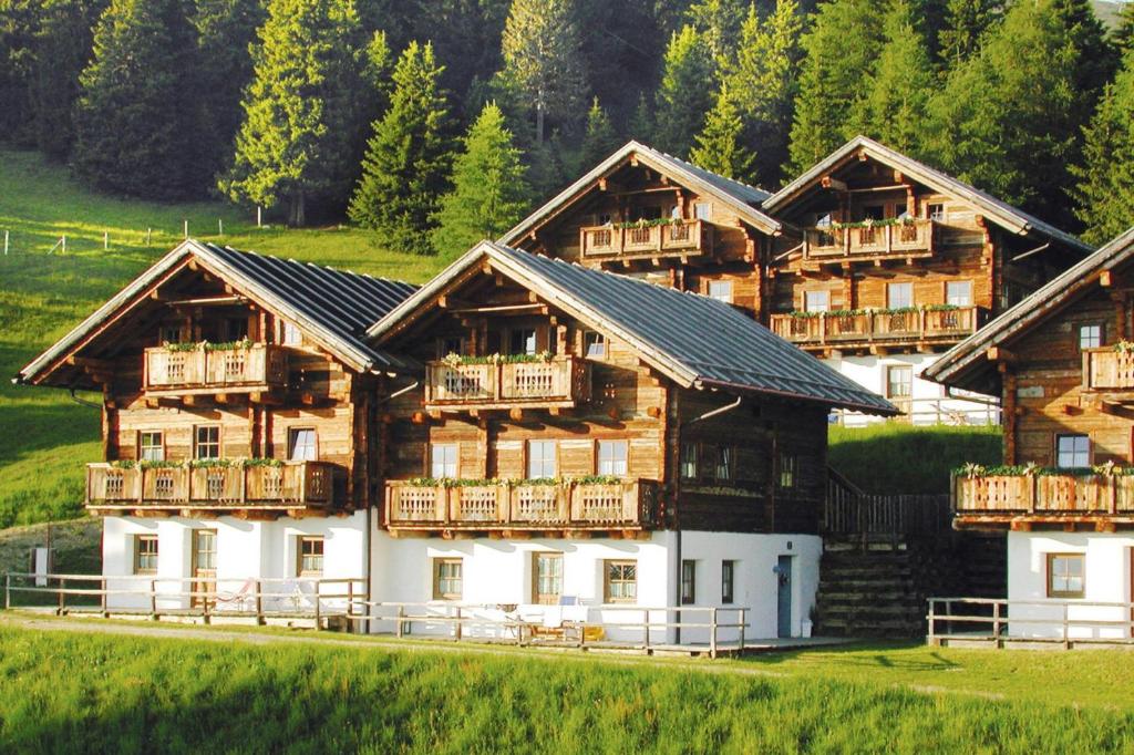 um grupo de edifícios de madeira com varandas em Almdorf Hochlienz Apartment Alm 30 em Obernussdorf