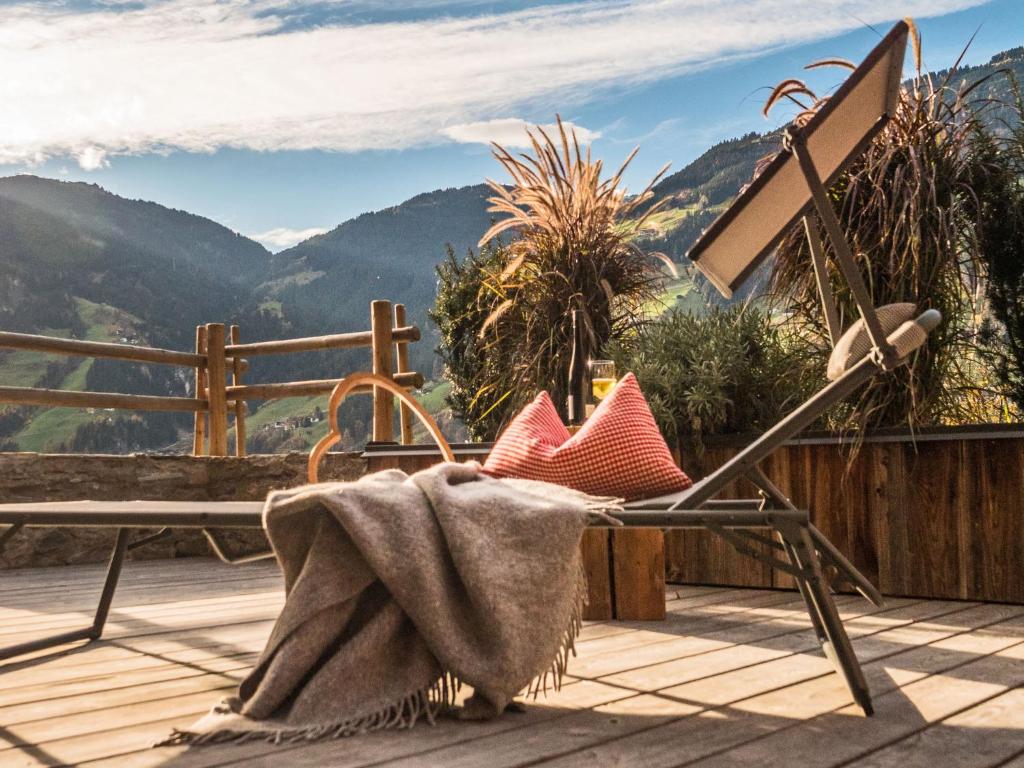 a chair with a blanket sitting on a deck with a view at Apartment in Ramsau im Zillertal with sauna in Ramsau im Zillertal