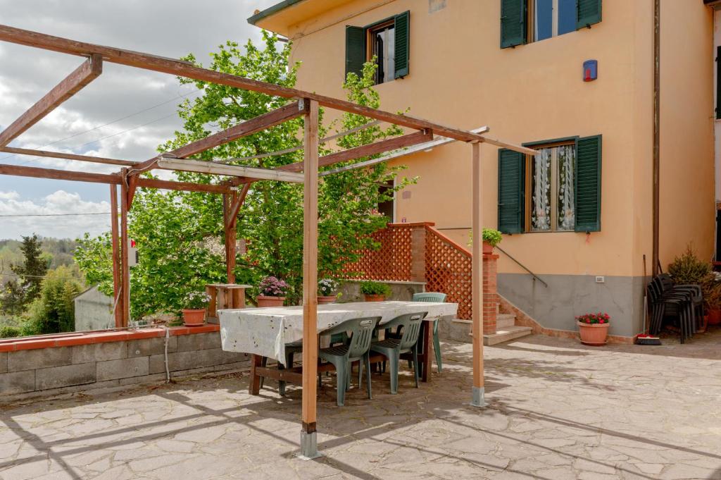 eine Terrasse mit einem Tisch und Stühlen vor einem Haus in der Unterkunft Tana Rosa in Montopoli in Val dʼArno