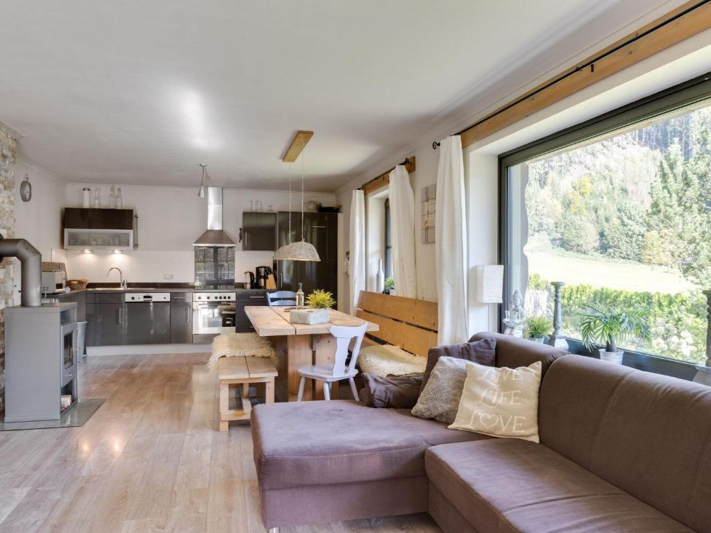 a living room with a couch and a kitchen at Stylish holiday apartment in Leogang Salzburgerland near ski area in Leogang