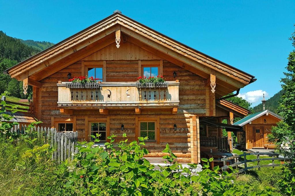 a log cabin with a balcony on top of it at Chalet Steinbock St Martin am Tennengebirge in Sankt Martin am Tennengebirge