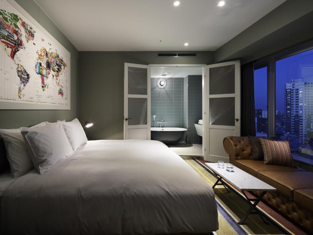 a bedroom with a large bed and a bathroom at Shinjuku Granbell Hotel in Tokyo