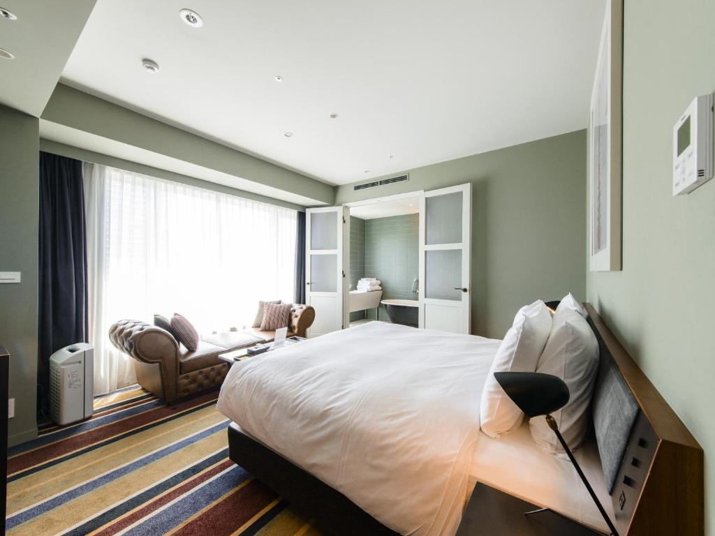 a bedroom with a large bed and a living room at Shinjuku Granbell Hotel in Tokyo