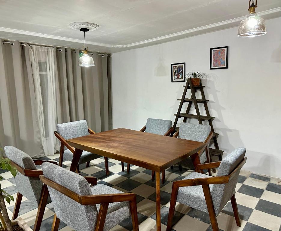 uma sala de jantar com uma mesa de madeira e cadeiras em Casa Madre Santa em Aguascalientes