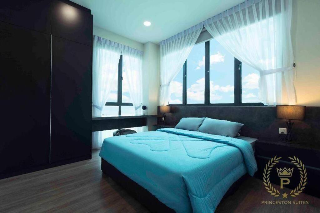 a bedroom with a blue bed and a large window at Princeton Suite @Kuching Airport in Kuching