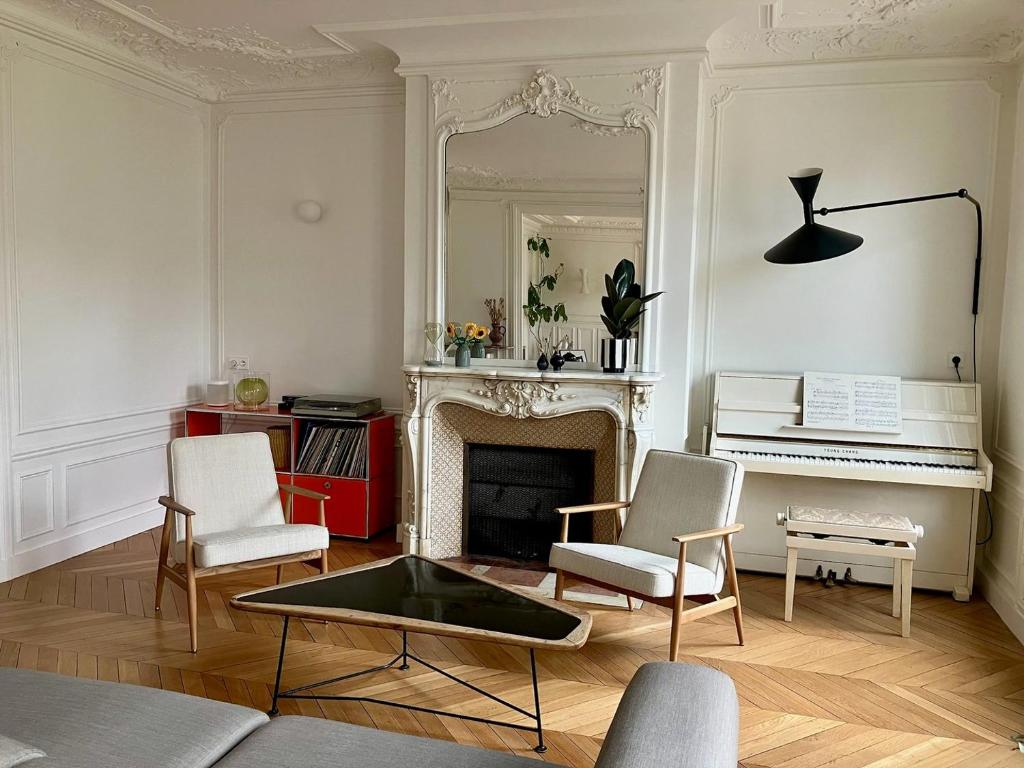 a living room with a fireplace and a piano at Deluxe Balcony Paris Gare de Lyon in Paris