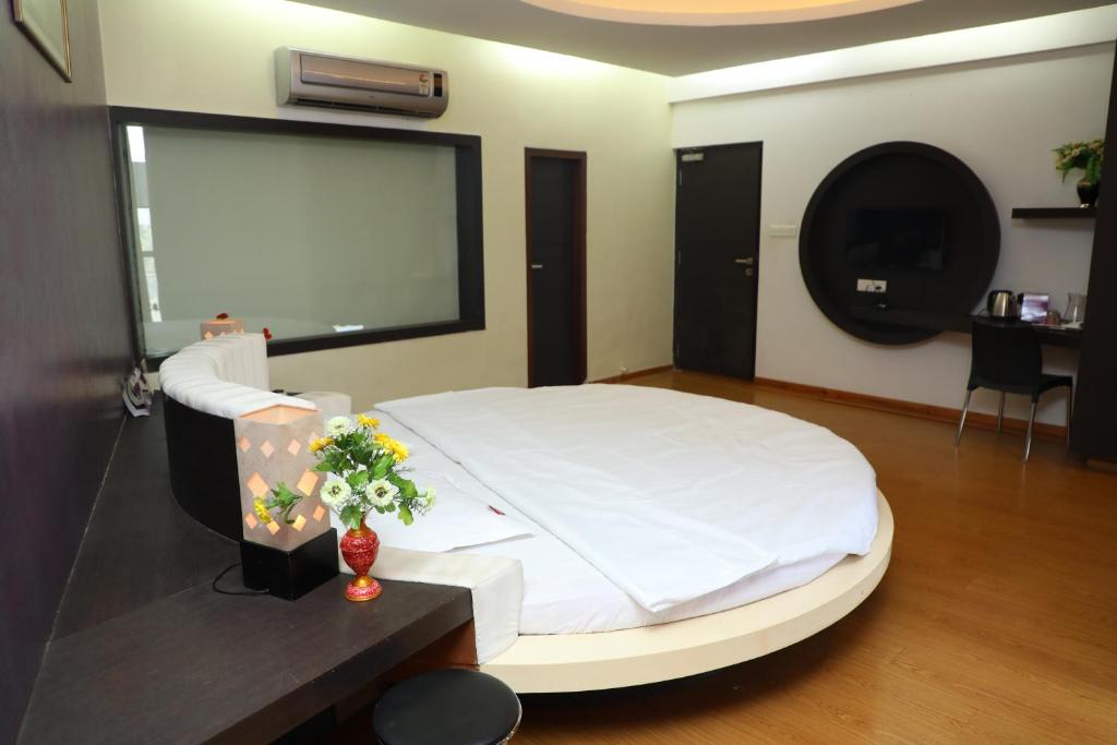 1 dormitorio con 1 cama blanca grande en una habitación en Vits Select Grand Inn, Ratnagiri, en Ratnagiri