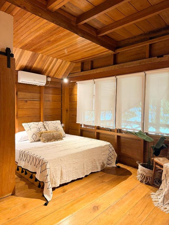 um quarto com uma cama num quarto com tectos em madeira em Villa Tala em Tua Pejat