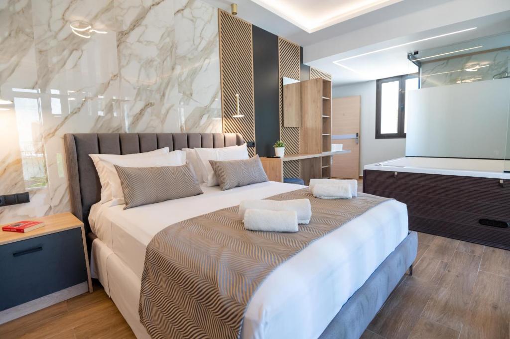 a bedroom with a large bed and a flat screen tv at John & Mary Suites in Rethymno Town