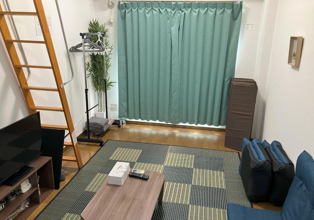 a living room with a green curtain and a table at SAKURA Stay FUKUOKA2 in Fukuoka