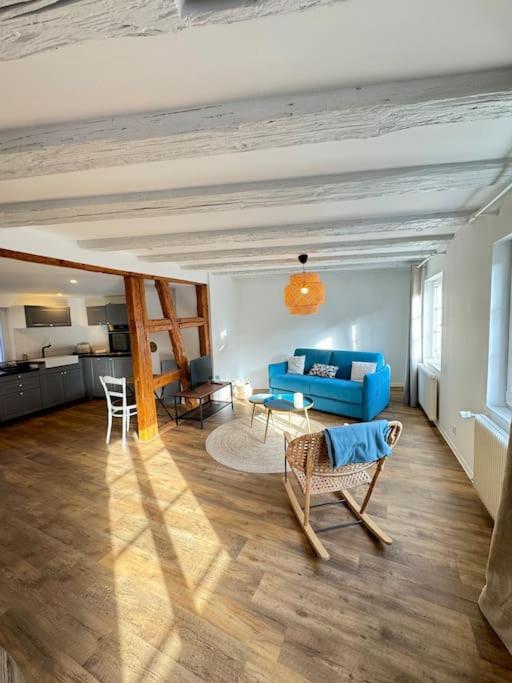 un salon avec un canapé bleu et des chaises dans l'établissement Les pensées d'Anne & Marie duplex 4/6 Personnes, à Eguisheim