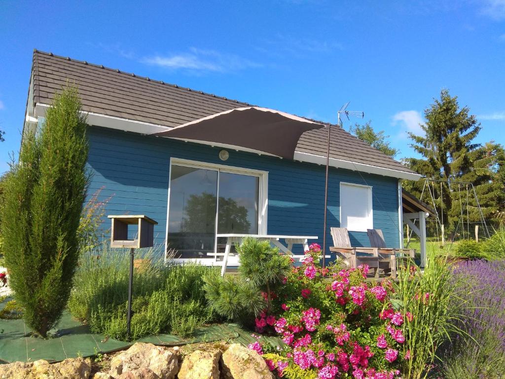 une maison bleue avec quelques fleurs devant elle dans l'établissement Gite Loire et Bois, à Saint-Martin-sur-Ocre