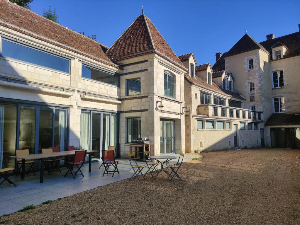 a patio with chairs and a table in front of a building at Hôtel des arts - Gîte Bande Dessinée dans le Perche - Spa in Rémalard
