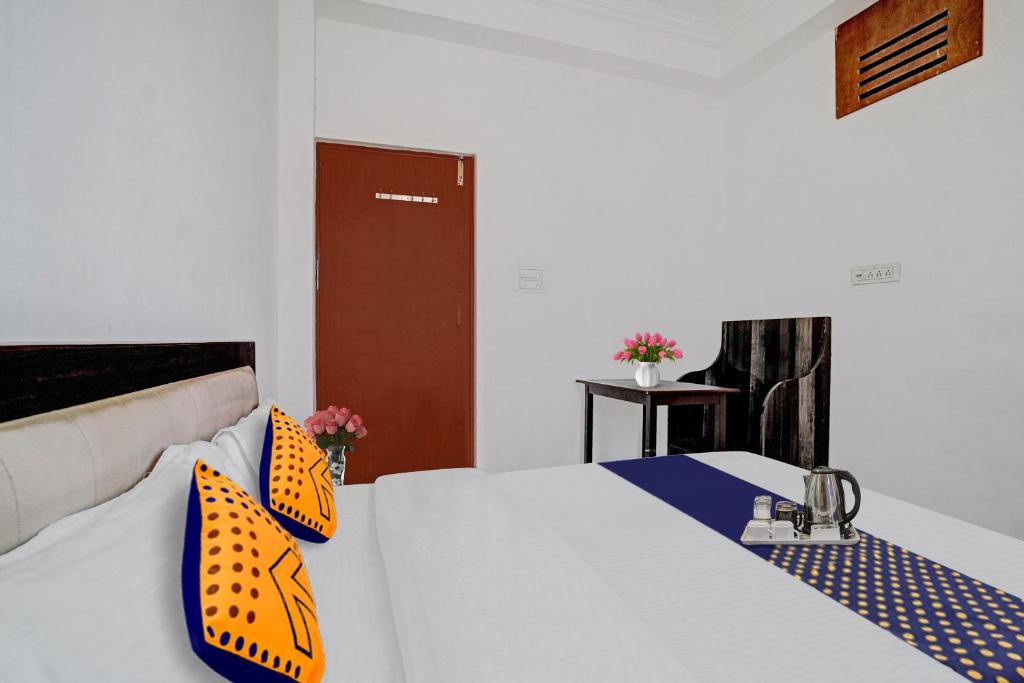 ジョードプルにあるSPOT ON Hotel Srbのベッドルーム1室(オレンジと青の枕が付いたベッド1台付)