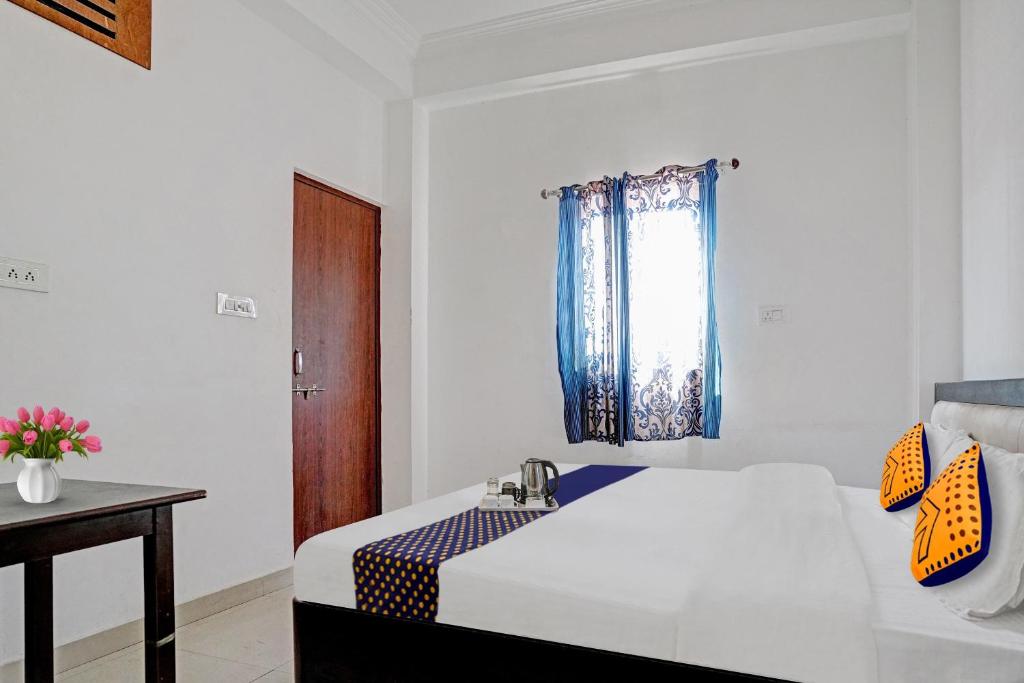 a bedroom with a bed with a sink and a window at SPOT ON Hotel Srb in Jodhpur
