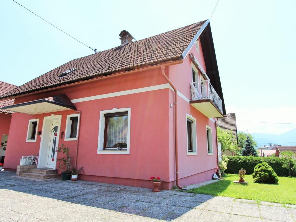 Casa de color rosa con ventana y balcón en Modern apartment with garden near the Petzen ski area in Eberndorf Carinthia en Eberndorf