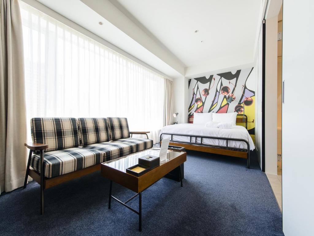 a living room with a couch and a bed at Shinjuku Granbell Hotel in Tokyo