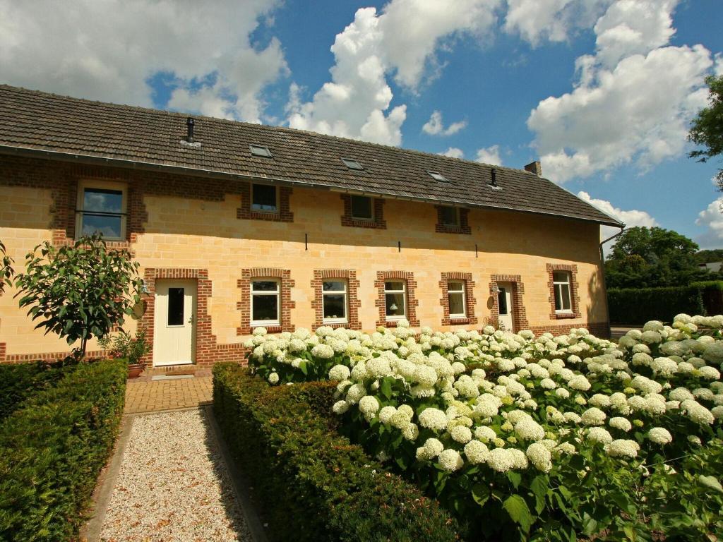 Een huis met witte rozen ervoor. bij Lovely Farmhouse in Wijlre with Forest nearby in Wijlre