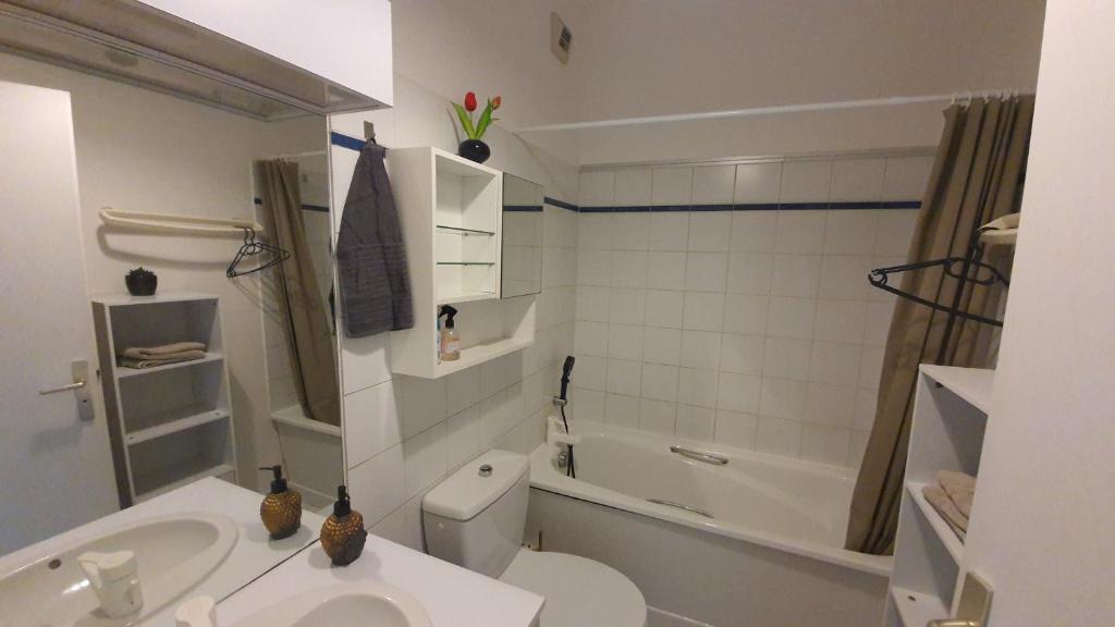 a bathroom with a toilet and a sink and a tub at Les hauteurs au pied de la gare - Proximité Paris et Orly in Villeneuve-Saint-Georges