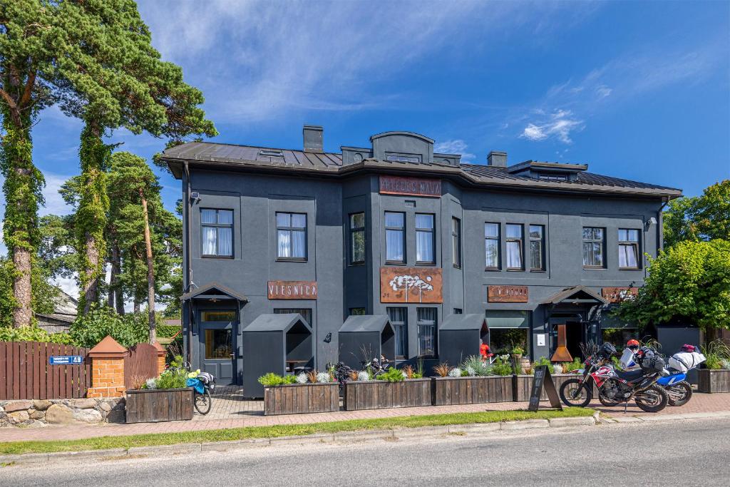 a house with two motorcycles parked in front of it at Priedes māja in Ainaži