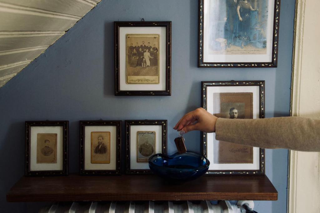a person brushing a blue bowl on a wall with pictures at Bed and Breakfast da Peppino in Bianchi