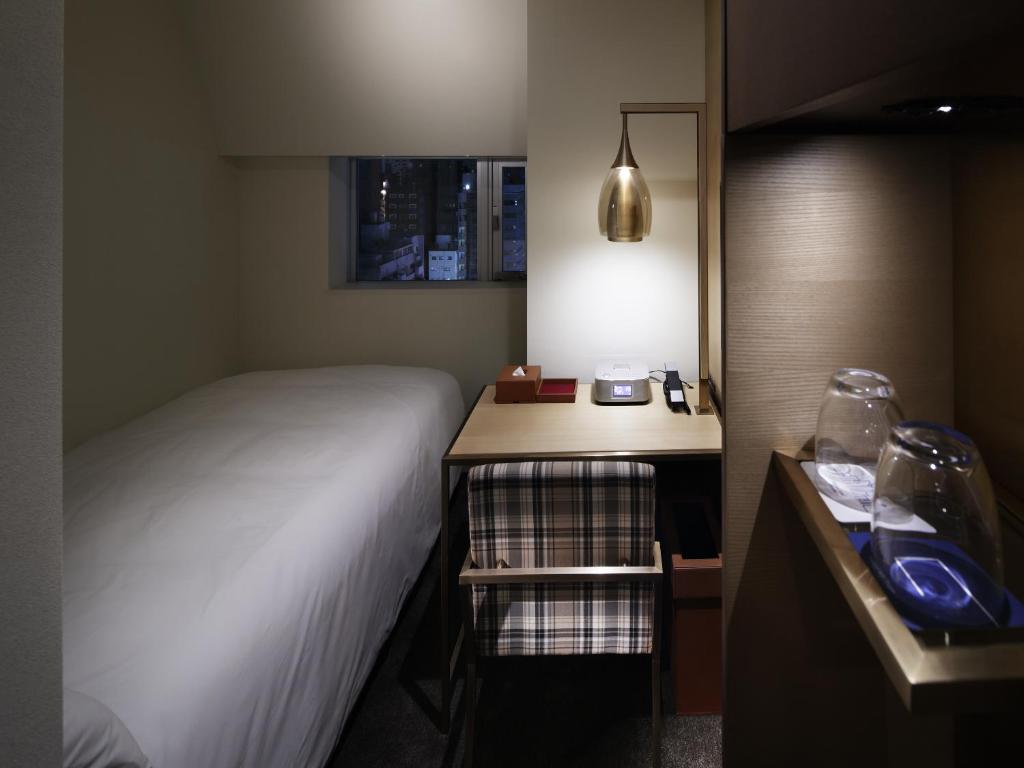 a small room with a bed and a nightstand with a bed sidx sidx sidx at Shinjuku Granbell Hotel in Tokyo