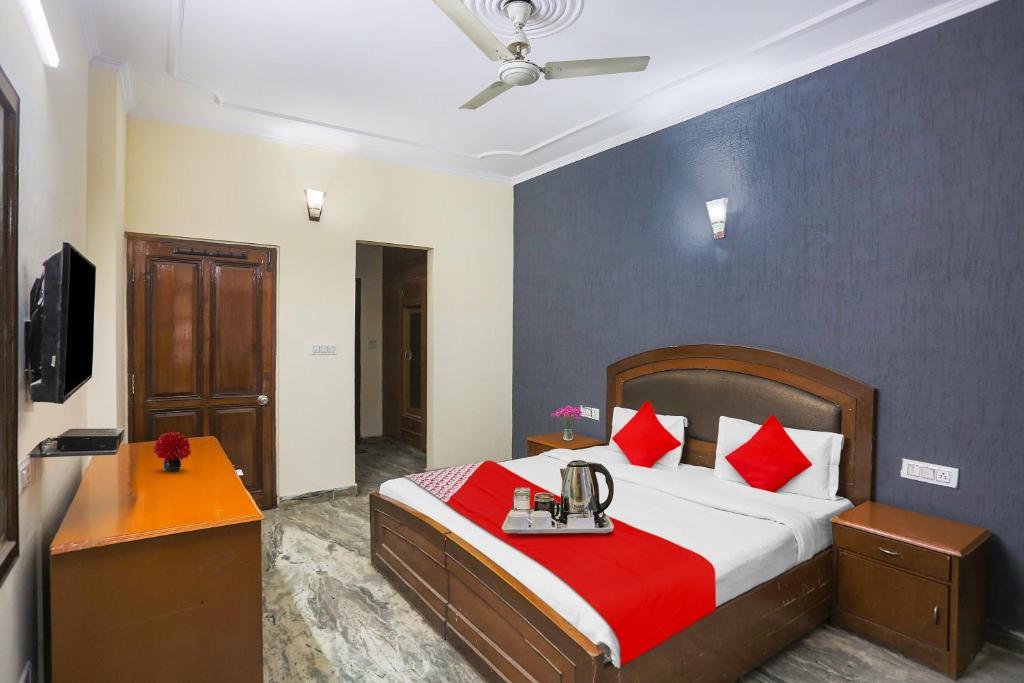 1 dormitorio con 1 cama grande con almohadas rojas en Flagship Av Homes Near Aravali Biodiversity Park, en Gurgaon