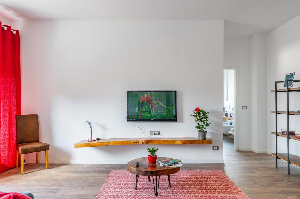 uma sala de estar com uma mesa e uma televisão na parede em Verona - Sweety Apartment with Balcony! em Verona