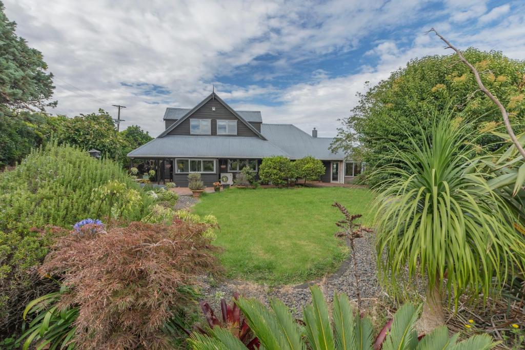 a house with a garden in front of it at Relax at Redoubt - Auckland Holiday Home in Auckland