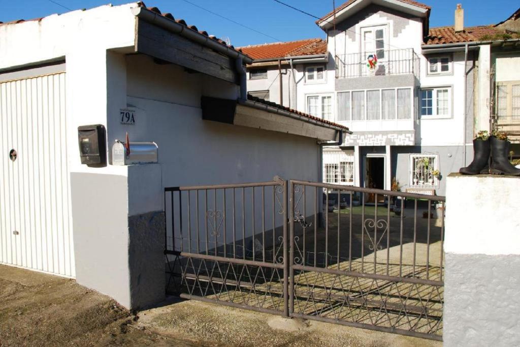 a white building with a gate in front of it at Carmen - Habitación con vistas al mar in Santander