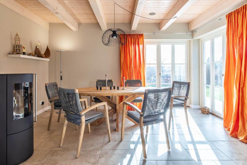 comedor con mesa de madera y sillas en Ferienhaus Söss Diek, en Gross Schwansee