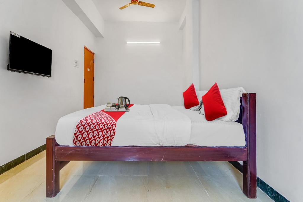 a bedroom with a bed with red pillows on it at Flagship Cruze Residency in Coimbatore